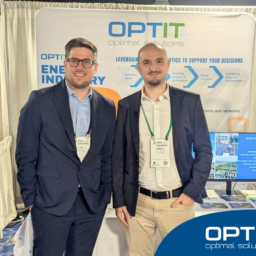 Due giovani professionisti stanno in piedi di fronte allo stand di Optit a una fiera a tema Energy