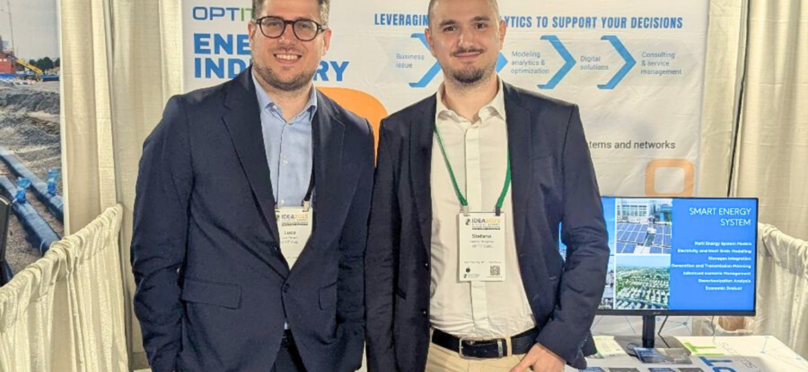 Due giovani professionisti stanno in piedi di fronte allo stand di Optit a una fiera a tema Energy