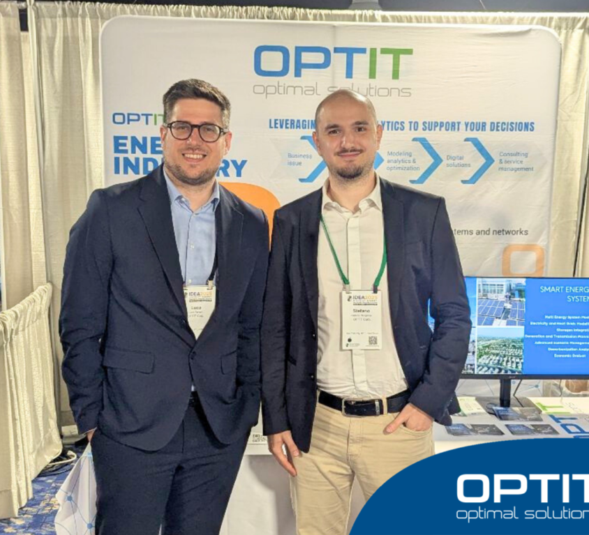 Due giovani professionisti stanno in piedi di fronte allo stand di Optit a una fiera a tema Energy